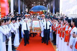 Le Premier ministre Le Minh Hung (à droite), l’ancien président Nguyen Minh Triet (à gauche) et d’autres délégués escortent les dépouilles des martyrs depuis le parc Le Thi Rieng. Photo : VNA