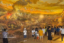 Des touristes admirent une peinture panoramique de la campagne de Diên Biên Phu au musée de la Victoire de Diên Biên Phu. Photo : VNA