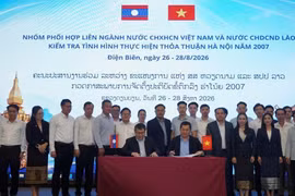 Des représentants du groupe de coordination interministériel Vietnam-Laos signent le procès-verbal de la réunion. Photo : Ministère de l’Industrie et du Commerce