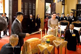 Le roi Maha Vajiralongkorn Phra Vajiraklaochaoyuhua et la reine Suthida Bajrasudhabimalalakshana de Thaïlande effectuent les rites traditionnels d'offrande de bougies et de fleurs à la pagode Quan Su. Photo: VNA