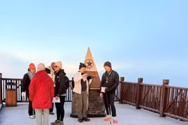Les touristes sont ravis de découvrir la glace au sommet du mont Fansipan. Photo : VNA