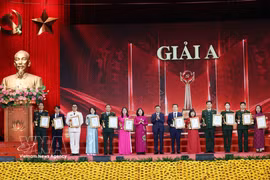 Le permanent du Secrétariat Tran Cam Tu (7e, droite) et Mme Bui Thi Minh Hoai (7e, gauche) décernent 12 premiers prix (prix A) aux auteurs et collectifs d'auteurs distingués. Photo: VNA