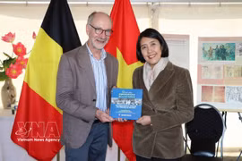 L'ambassadrice Nguyen Huong Tra remet le livre « L'affection des peuples du monde pour le président Ho Chi Minh » à Benjamin Pestieau, secrétaire général adjoint du Parti du travail de Belgique (PTB). Photo : VNA 