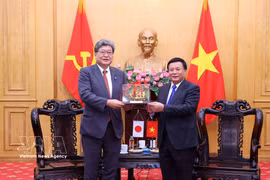 Le président du Conseil théorique central du Vietnam, Nguyên Xuân Thang (droite) remet un cadeau au secrétaire général par intérim du PLD du Japon, Koichi Hagiuda. Photo: VNA