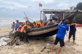 Les autorités et les pêcheurs ramènent les bateaux à terre pour s'abriter de la tempête. Photo : VNA