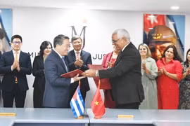 Le ministre vietnamien de la Justice, Nguyen Hai Ninh (gauche) et son homologue cubain, Oscar Manuel Silvera Martínez, signent un accord portant sur un projet d'assistance technique destiné au ministère cubain de la Justice. Photo: VNA