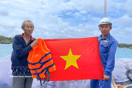 Remise d'un drapeau national à des pêcheurs. Photo : VNA