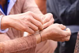 La personne à qui l’on attache le fil doit le garder au poignet toute l’année, sans jamais le retirer, jusqu’à la prochaine cérémonie d'accueil du premier tonnerre. Photo : VNA