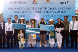 Lors de la cérémonie d'accueil, le comité d'organisation a offert des fleurs et des cadeaux à trois heureux invités du vol VN337 Osaka-Da Nang. Photo : VNA