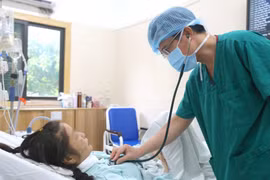 Un médecin vérifie l'état de santé de la patiente après la greffe. Photo : VietnamPlus