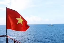 Le drapeau national flotte au cœur du ciel et de la mer de la Patrie
