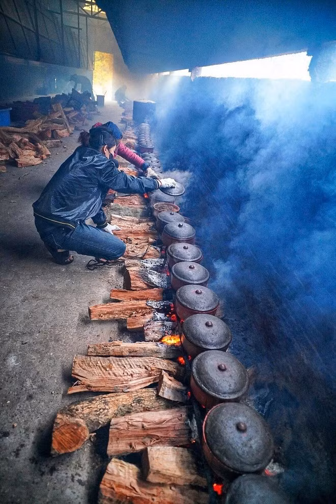 Le feu est le cœur battant du cá kho de Vu Dai. Une flamme vive est d'abord attisée pour porter rapidement l'eau à ébullition, puis réduite en braises douces. C'est sur ces braises que le poisson mijote pendant au moins 12 heures. La marmite ne pourra pas être réutilisée.Photo : VNA