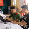 Un policier du quartier de Ly Thuong Kiet, dans la province de Ninh Binh, explique aux habitants comment utiliser l’application VNeID sur leur smartphone. Photo: VNA