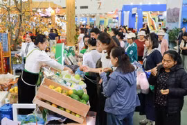 Un grand nombre de visiteurs au stand des produits typiques et emblématiques de la province de Son La pour acheter des spécialités locales. Photo: VNA