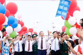 Le secrétaire général du Parti et président de la République, To Lam, et des délégués relâchent des colombes sur le pont de Hien Luong. Photo : VNA