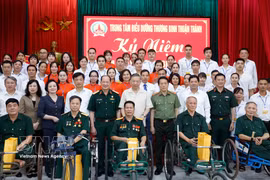Le secrétaire général du Parti et président de l’État, To Lam, et les délégués aux côtés du personnel et des anciens militaires blessés ou atteints de graves séquelles pris en charge au Centre de Thuan Thanh. Photo : VNA