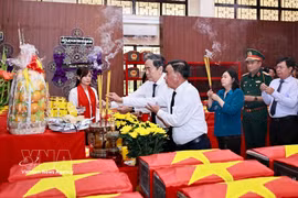 Le président de l'Assemblée nationale, Tran Thanh Man, le membre permanent du Secrétariat du Comité central du Parti, Tran Cam Tu, et d'autres délégués brûlent des bâtonnets d'encens en mémoire des martyrs au dépôt des restes de martyrs. Photo : VNA