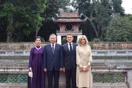 Le secrétaire général du Parti, Tô Lâm, et son épouse Ngo Phuong Ly, le président français, Emmanuel Macron, et son épouse Brigitte Macron, au Temple de la Littérature – Quoc Tu Giam. Photo: VNA