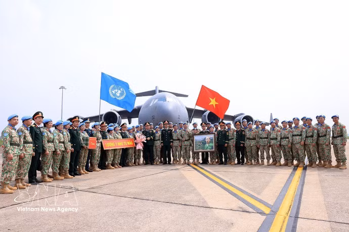 Le général de corps d’armée Le Quang Dao, chef d’état-major général adjoint de l’Armée populaire du Vietnam, et des responsables des unités posent pour une photo avec les cadres et militaires avant leur départ pour une mission internationale. Photo: VNA