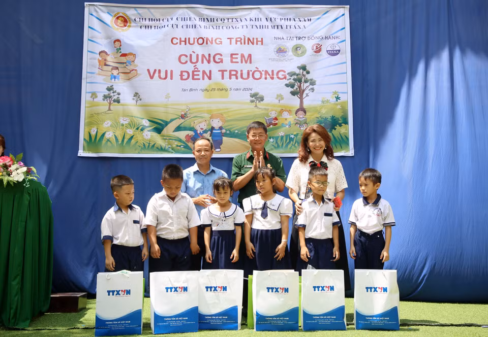 Tran Trang Duong (au milieu), président de l'Association des anciens combattants de l'Agence vietnamienne d'information, et Huynh Thi Mong Tuyen, directrice de la Sarl du commerce et de l'import-export Yamamoto-Huynh, remettent des cadeaux à des élèves.