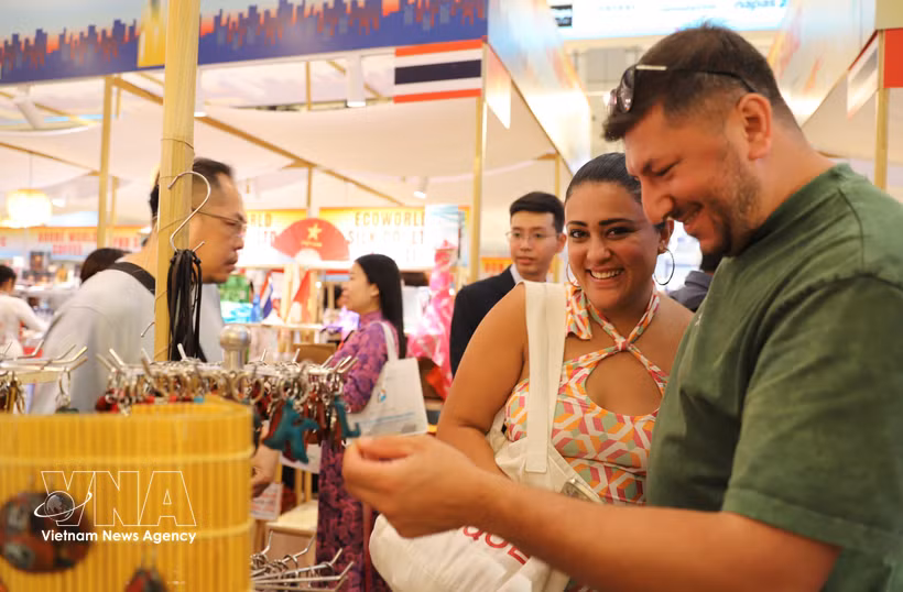 Des visiteurs étrangers apprécient les produits artisanaux présentés lors de l’événement. Photo: VNA