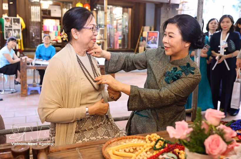 Mme Ngo Phuong Ly, épouse du secrétaire général du Parti et président de la République To Lam (droite) et Mme Kyu Kyu Hla, épouse du président birman Min Aung Hlaing, visitent le village de la soie de Van Phuc. Photo: VNA