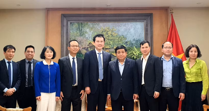 Le vice-Premier ministre Nguyên Chi Dung (4e de droite à gauche) prend la photo avec la délégation de Qualcomm. Photo: VNA