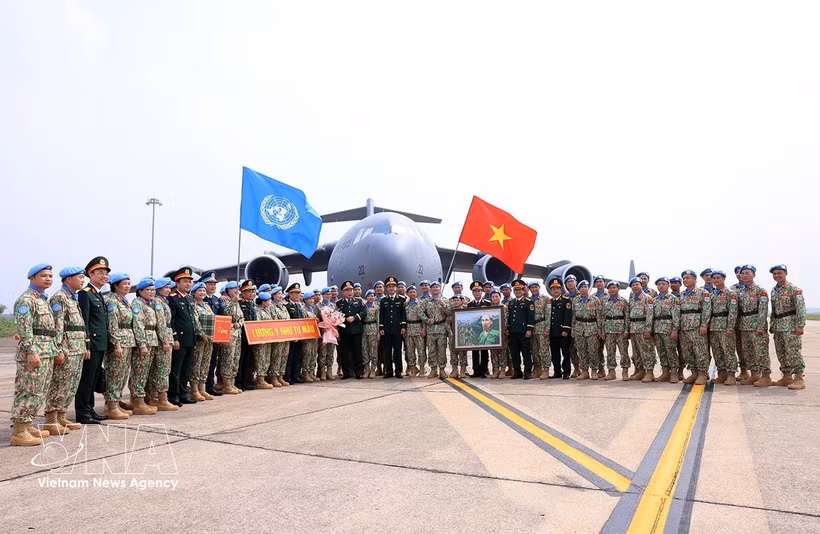 Le général de corps d’armée Le Quang Dao, chef d’état-major général adjoint de l’Armée populaire du Vietnam, et des responsables des unités posent pour une photo avec les cadres et militaires avant leur départ pour une mission internationale. Photo: VNA