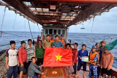 Les forces de l'ordre maritimes de Hô Chi Minh-Ville offrent un drapeau national et diffusent des informations sur la pêche INN aux pêcheurs. Photo: VNA