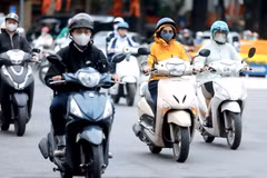 Des gens se déplacent pour se rendre au travail par une journée froide à Hanoi. Photo : VNA