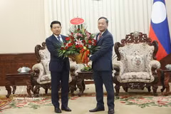 L’ambassadeur du Vietnam au Laos, Nguyên Minh Tâm (à droite), transmet une corbeille de fleurs du Premier ministre vietnamien Lê Minh Hung au Premier ministre lao Saleumxay Kommasith. Photo : VNA