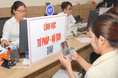 Des citoyens scannent des codes QR pour consulter les procédures et les démarches relatives aux questions judiciaires et d'état civil. Photo : VNA