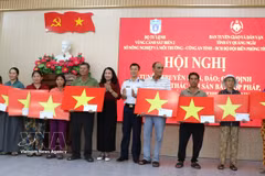 Des représentants du commandement de la 2e région des garde-côtes et du Comité de l'information, de l'éducation et de la mobilisation des masses du Comité provincial du Parti de Quang Ngai offrent des cadeaux et des drapeaux nationaux aux pêcheurs. Photo : VNA
