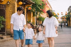 Une famille de touristes balade dans les ruelles étroites de la charmante cité de Hôi An. Photo : cafef.vn