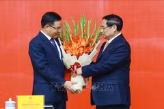 Le Premier ministre Pham Minh Chinh (à droite) félicite Lê Manh Hung pour sa nomination au poste de ministre par intérim de l’Industrie et du Commerce. Photo : VNA