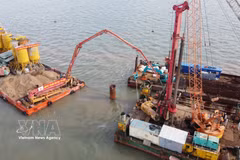 Des ingénieurs et ouvriers travaillent sur le chantier du projet de liaison vers l’île de Hon Khoai. Photo : VNA