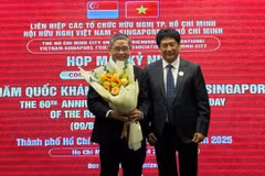 Le président de l'Association d'amitié Vietnam - Singapour (gauche) offre un bouquet de fleurs au consul général de Singapour à Hô Chi Minh-Ville, Pang Te Cheng. Photo: sggp