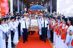 Le Premier ministre Le Minh Hung (à droite), l’ancien président Nguyen Minh Triet (à gauche) et d’autres délégués escortent les dépouilles des martyrs depuis le parc Le Thi Rieng. Photo : VNA