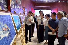 Les visiteurs contemplent des oeuvres exposées. Photo: VNA