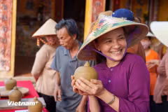 Le sourire radieux d'une artisane de Thanh Ha après avoir achevé une pièce de poterie fraîchement façonnée. Photo : VNA