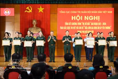 Le général Le Quang Minh, chef adjoint du Département général de la politique, et le général Pham Truong Son, chef d'état-major adjoint de l'Armée populaire du Vietnam, remettent des satisfecit à des collectifs et à des individus exemplaires. Photo : VNA