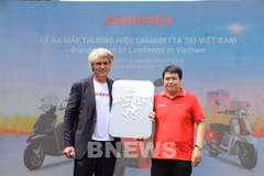 Un représentant de Lambretta remet le logo de l'entreprise à son distributeur officiel, la société Lamscooter Vietnam. Photo : VNA