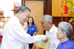 Le secrétaire général To Lam offre des cadeaux aux familles des personnes méritantes. Photo : VNA