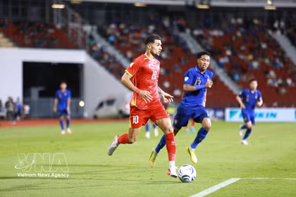 Hoang Hen (numéro 10 – équipe nationale du Vietnam) tente de dribbler un joueur thaïlandais. Photo : VNA