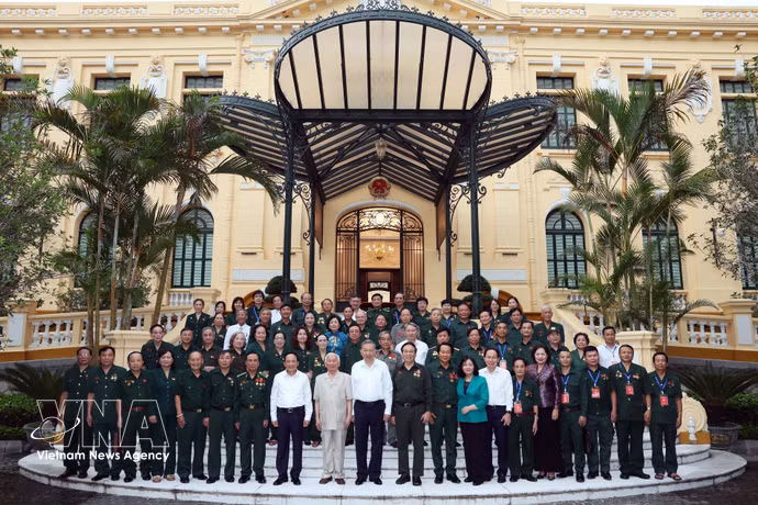 Le secrétaire général du Parti communiste du Vietnam et président de la République, Tô Lâm, et des délégués de l’Association des anciens Jeunes volontaires du Vietnam. Photo : VNA