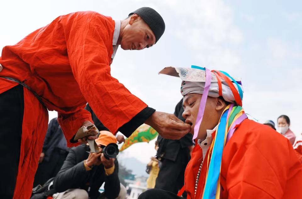 Le sorcier donne du riz à la personne qui passe le rituel « tu cai », à ce moment-là, il est considéré officiellement comme mature. Photo: VNA
