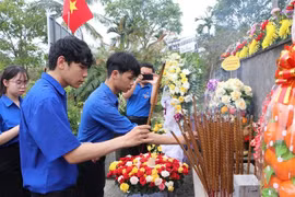 Des jeunes offrent de l'encens en commémoration des 504 civils innocents tués. Photo: VNA