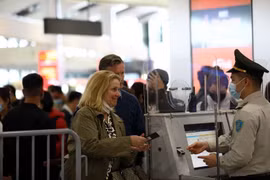 L'agent de sécurité aérienne vérifie les informations des passagers. Photo: VNA