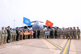 Le général de corps d’armée Le Quang Dao, chef d’état-major général adjoint de l’Armée populaire du Vietnam, et des responsables des unités posent pour une photo avec les cadres et militaires avant leur départ pour une mission internationale. Photo: VNA