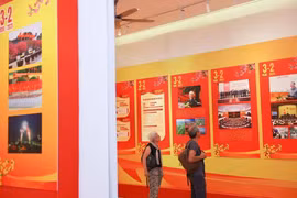 Des visiteurs internationaux visitent une exposition sur le Parti à Hanoi à l'occasion du 95e anniversaire de la fondation du Parti communiste du Vietnam. Photo: VNA